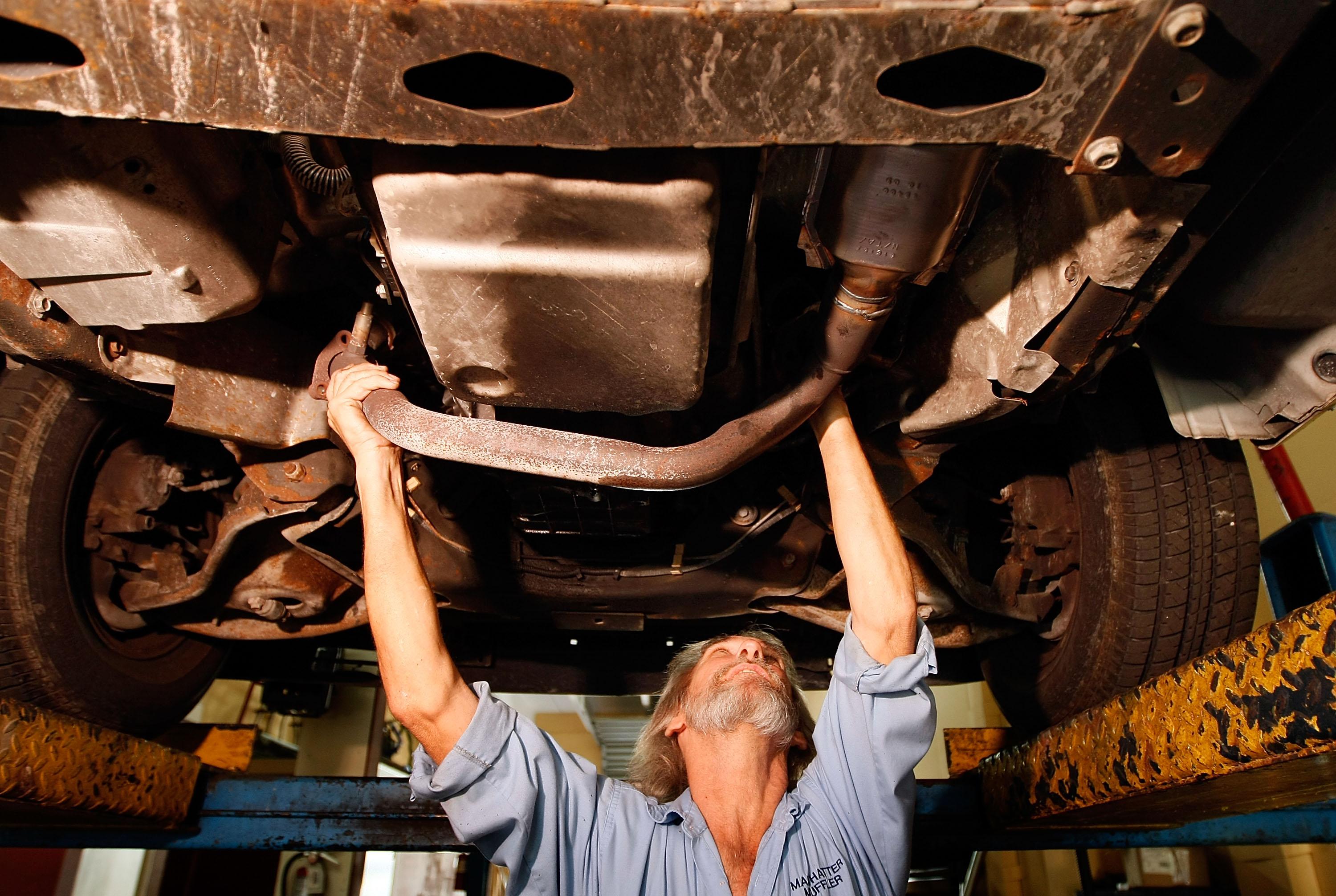 Mechanic Kevin Doyle checks a catalytic converter on a lorry. (Photo by Joe Raedle/Getty Images)
