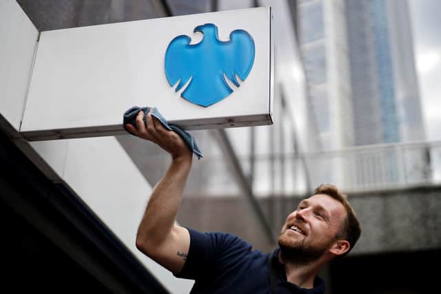 A man cleans a sign outside a branch of a Barclays bank in the City of London. The bank is offering up to £900 in cash to new customers who switch their current account and ISA (Photo: TOLGA AKMEN/AFP via Getty Images)