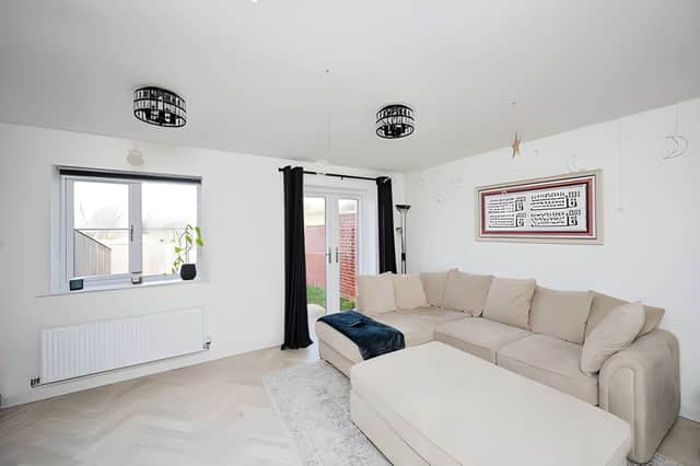 Patio doors fill the spacious lounge with natural light while linking the living space with the private garden.