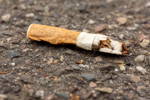 A discarded cigarette butt on the ground.