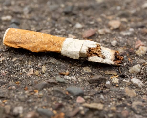 A discarded cigarette butt on the ground.