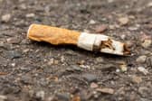A discarded cigarette butt on the ground.