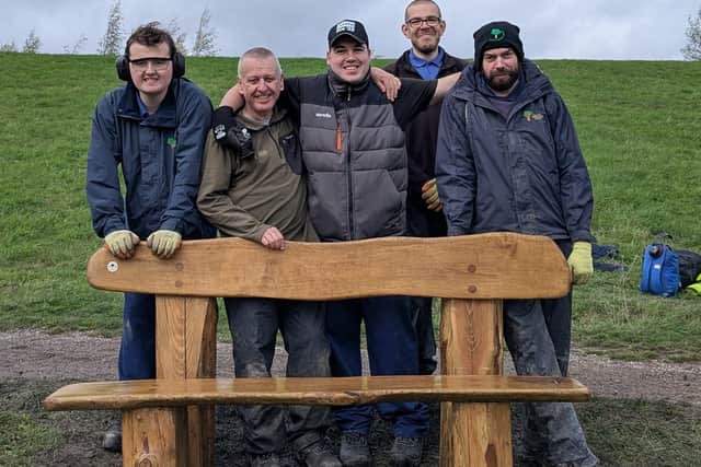 Team members and staff from Bolsover Woodlands Enterprise with a bench they created