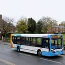 Stagecoach bus drives past a war memorial
