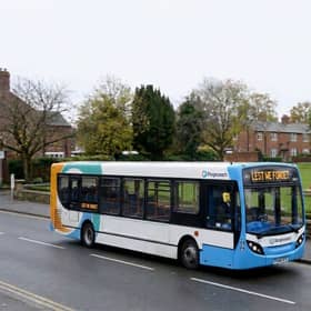 Stagecoach bus drives past a war memorial