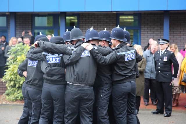 New police officers huddle after passing out.