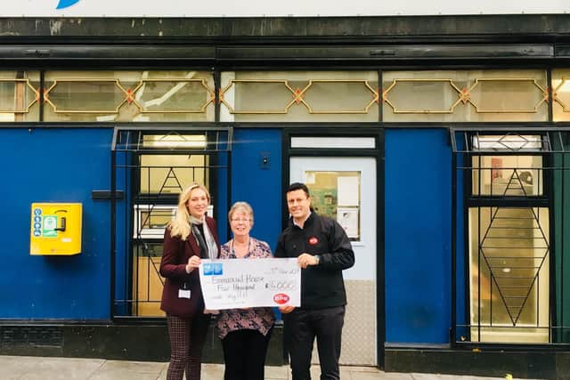 Sam and Stuart Handley hand over a 4,000 cheque to a representative from Emmanuel House.