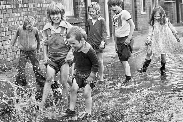 The long hot summer of 1976 and these Ince children made the most of the North West Water Authority testing a new water main at the junction of Ince Green Lane and Warrington Road to have some cool splashing fun, July 1976.