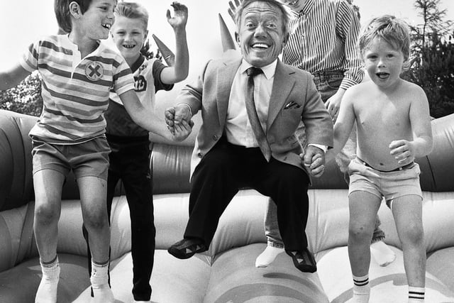 Kenny Baker, who played Star Wars robot R2D2, on the bouncy castle with young fans, after he opened a fun day at Wigan Rugby Union Club in aid of the NSPCC in 1989.