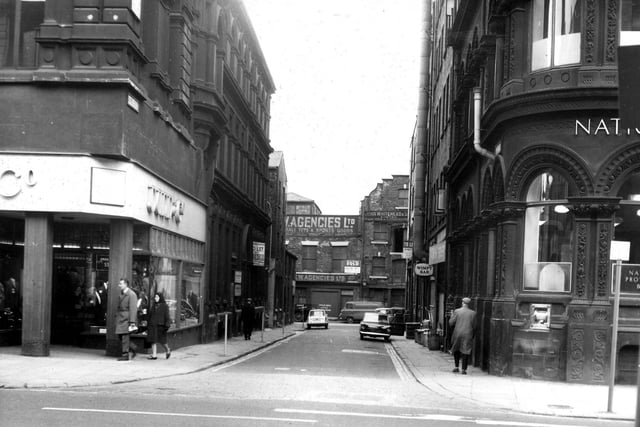 Looking along Alfred Street from Boar Lane. On the corners are Dunn & Co., hatters (left) and the National Provincial Bank (right).