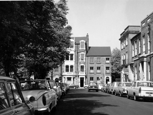 Recognise this view? It is Park Square. Cars are parked on both sides of the road. The trees are in full leaf.