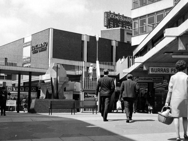 A view of the sculpture 'Androgyne' by Glenn Hellman 1965. A sign for the Locarno Mecca Dancing can be seen on a building in the background.