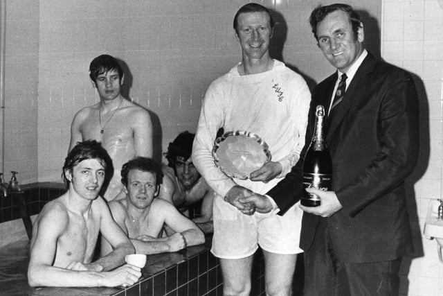Don Revie presents Jack Charlton with a bottle of champagne and the Footballer of the Month trophy in the changing room after a game in April 1972.