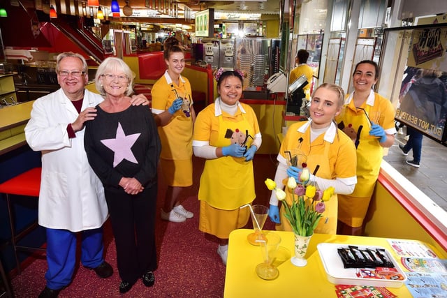 Owners Guilian and Theresa and Alonzi with staff in the Harbour Bar. The staff are wearing the familiar yellow and white uniforms