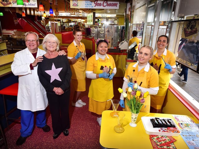 Owners Guilian and Theresa and Alonzi with staff in the Harbour Bar. The staff are wearing the familiar yellow and white uniforms