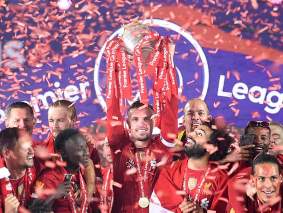 Jordan Henderson of Liverpool holds the Premier League Trophy aloft along side Mohamed Salah as they celebrate winning the League during the presentation ceremony of the Premier League match between Liverpool FC and Chelsea FC at Anfield on July 22, 2020 in Liverpool, England. (Photo by Laurence Griffiths/Getty Images)