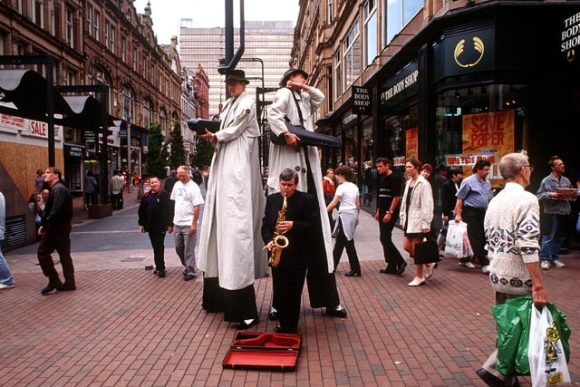 Stilt-walking gangsters Artizani entertain shoppers in August 1997.