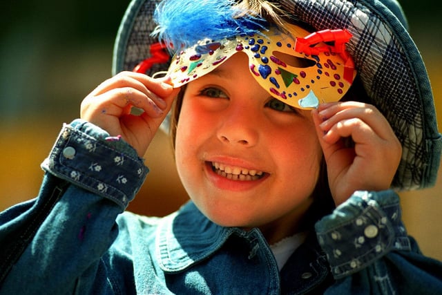 Five-year-old Alice Pawson from Methley, tries on her face mask at the launch of Rhythms of the City on Lands Lane in August 1998.