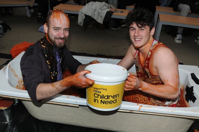 CHILDREN IN NEED 2015 - Students at St John Rigby College, Orrell, dress up in super hero fancy dress as tutor Chris Peacock, left, and student Craig Mullen, right, sit in a bath of beans, while colleagues and fellow students make donations to pour more beans on them, to raise funds for Children in Need.