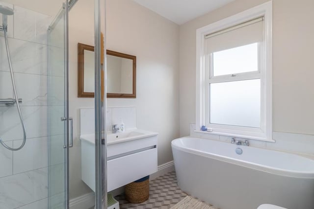 The contemporary bathroom with large bath, separate shower and heated towel rail