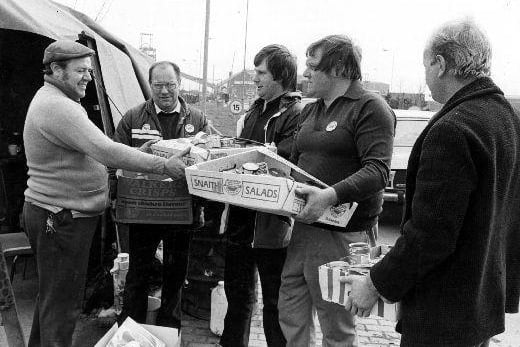 Refuse collectors handing over a box of groceries at Pontefract Prince of Wales Colliery