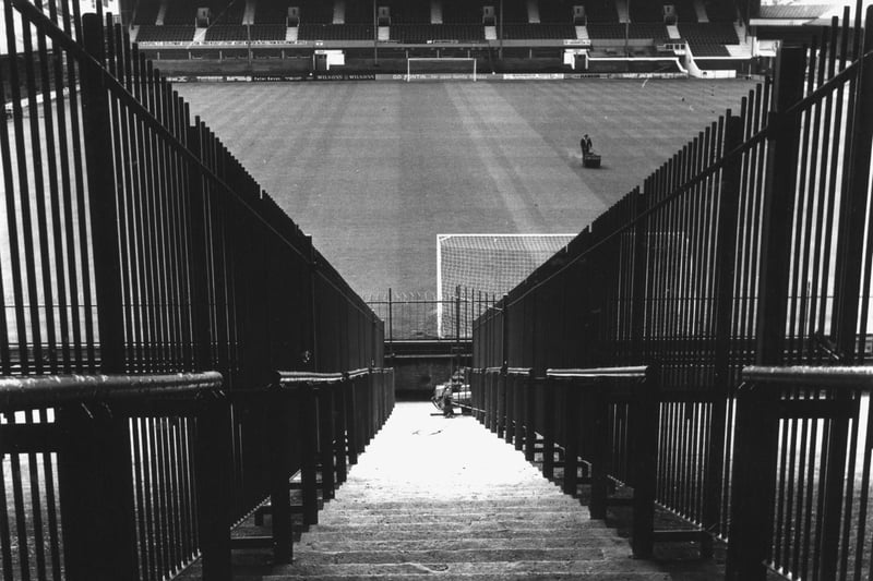 The view from the Kop showing the railings installed to keep rival fans apart and a
lone groundsman hard at work mowing the pitch