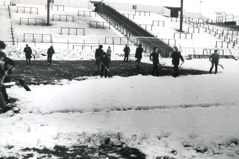 Volunteers struggle to clear the snow from the pitch at Blackpool Football Club, Bloomfield Road in time for the match against Tranmere on Boxing Day 1981