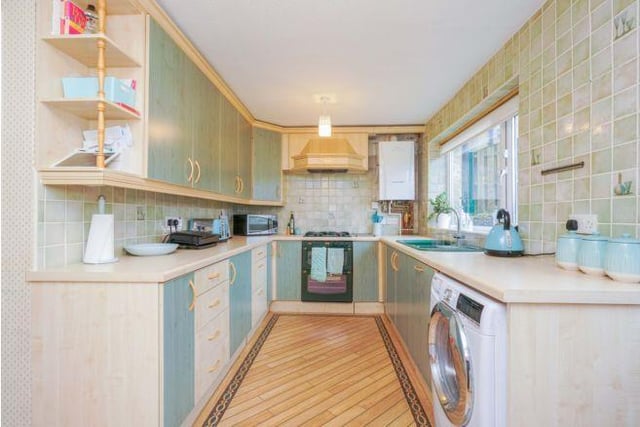The kitchen is fitted with  a range of wall and base units and integrated appliances. The room has a window and door out into the rear garden.