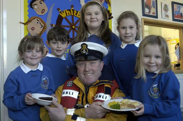 Lifeboat coxswain Mike Russell is served up a treat by Stakesby School pupils.