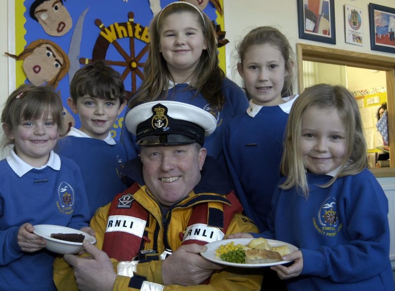 Lifeboat coxswain Mike Russell is served up a treat by Stakesby School pupils.