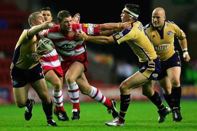 WIGAN, ENGLAND - 2 SEPTEMBER 2005:  Danny Tickle of Wigan breaks between Matt Diskin (L) and Kevin Sinfield (R) during the Engage Super League match between Wigan Warriors and Leeds Rhinos at the JJB Stadium on September 2, 2005 in Wigan, England