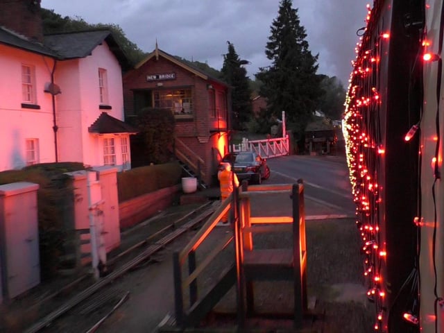 Lit-up train provides a spectacle for motorists waiting at the level crossing.
picture: Robert Townsend.