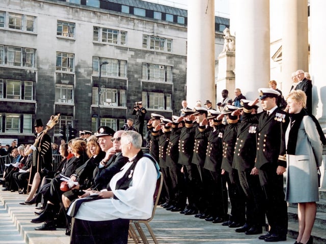 The Civic Hall steps where special guests attending the Ark Royal parade are positioned. Towards the left is the Mace Bearer for the City of Leeds, John Wilson, in full ceremonial dress carrying the Mace. Seated guests include the Chaplain of the Ark Royal on the right.