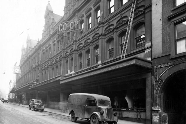 November 1944 and pictured is the Leeds Industrial Co-operative Society. On the building is a large clock and a sign saying Co-op. A Co-op van is parked outside the shop.
