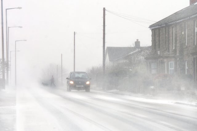 Vehicles struggle along Bolton Road, Abbey Village, near Preston as the snow closes in during 2006