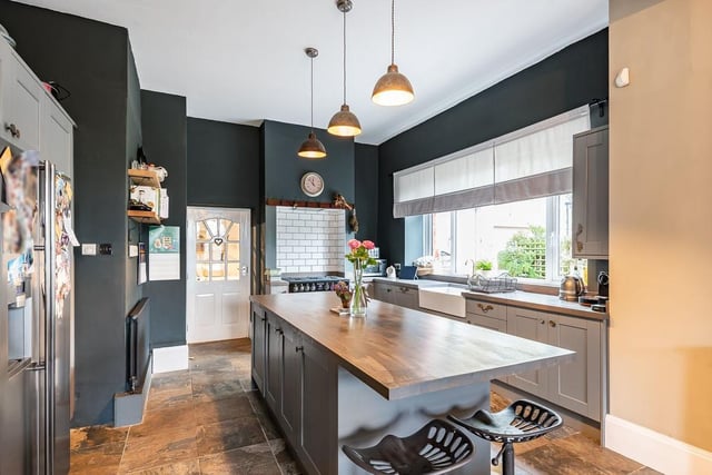 The kitchen diner is a contemporary but warm, inviting space. It boasts a shaker style kitchen with central island and breakfast bar and stone floor.