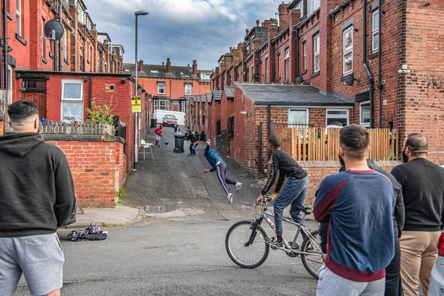 Young adults and children play street cricket in a back street off Hovingham Avenue in Harehills. Picture: Tony Johnson.
