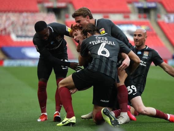 Callum Morton is mobbed by his team-mates after making it 2-0 at Wembley. Picture: Getty