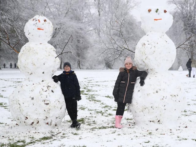 Two very impressive snowmen and two very proud creators. Photo: Getty Images