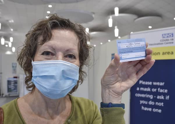 Sue Welch shows off her vaccination card.