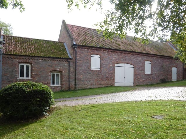 The Grade II listed barn and part of one of the converted cottages.