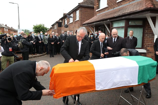 Sean Murray (left), Gerry Kelly (second left), and Padraic Wilson (centre) place an Irish flag onto the coffin of senior Irish Republican and former leading IRA figure Bobby Storey ahead of his funeral in west Belfast