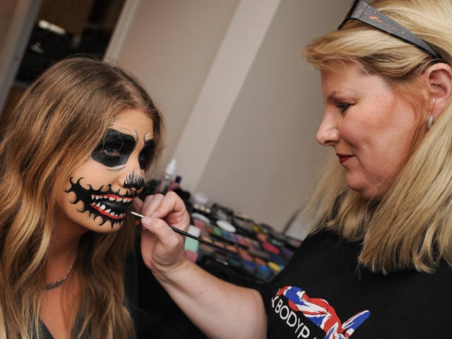 Tina Smith, who won a national body art painting award, pictured painting former Chad reporter Katie Butler's face for Halloween.