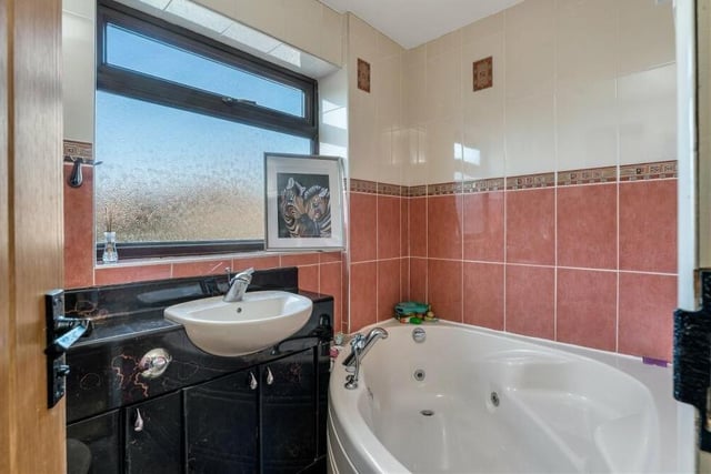 As well as the shower room downstairs, the property includes this sparkling family bathroom on the first floor. A Jacuzzi bath is complemented by a vanity unit, low-flush WC, heated towel-rail, fully tiled walls and spotlights.