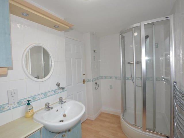 This striking shower room can also be found on the first floor of the £400,000 chalet bungalow. Fully tiled, it boasts a three-piece suite comprising a shower cubicle with Grohe shower, wash hand basin, low-level WC and vanity storage.