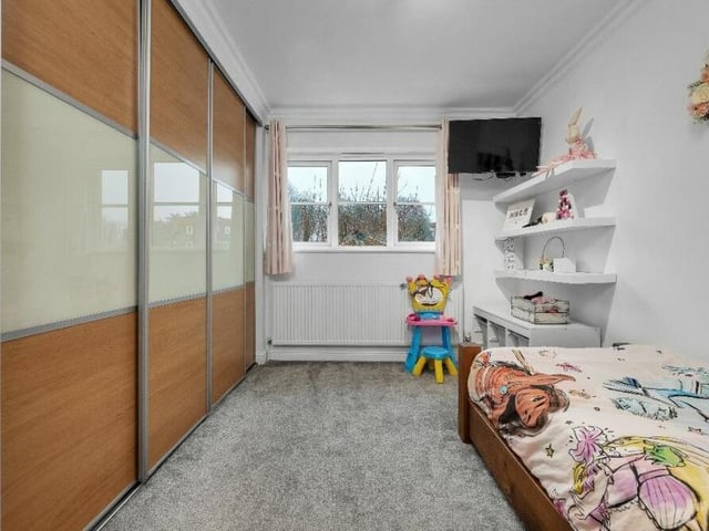 This bedroom has internally built wardrobes, with inset hanging rails and shelving.