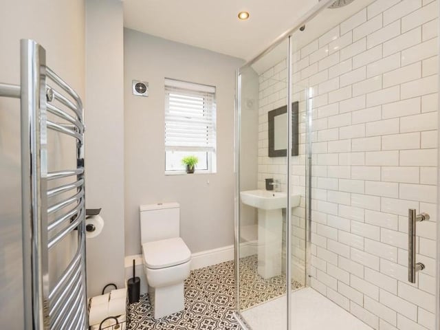 The ground floor also houses this attractive shower room, complete with walk-in shower cubicle, wash hand basin, low-flush WC and heated towel-rail.