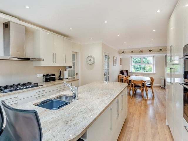 Our last look at the open-plan kitchen shows a breakfast bar with space for stools, 14 ceiling spotlights and, in the distance, a dining area.