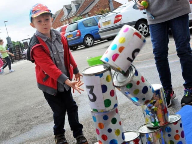 Louis Rhodes successfully takes aim at stacked cans at the Sutton Road Primary School summer fair in 2014.