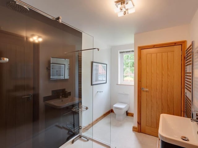 The second bedroom opens in to this Jack and Jill shower room, which is suitable for the whole family. It includes a walk-in shower, wash hand basin with chrome mixer tap, low-level WC, chrome, heated towel-rail and fitted vanity mirror. A storage cupboard houses the hot-water cylinder.